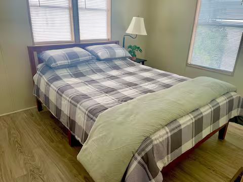 Bedroom with plaid bedding at Sarasota Resort Cottage